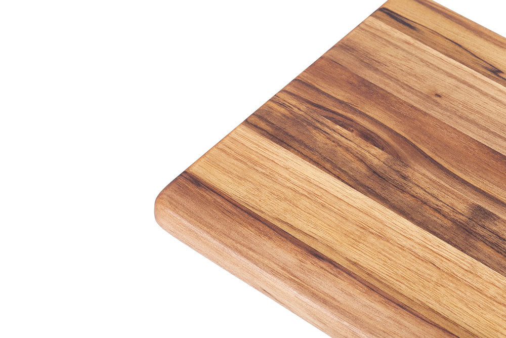 Rectangle teakwood cutting board corner showing the edge grain wood pattern and texture.