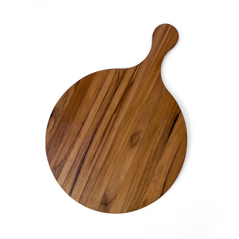 Round edge grain teakwood serving board with a paddle handle, isolated on a white background.