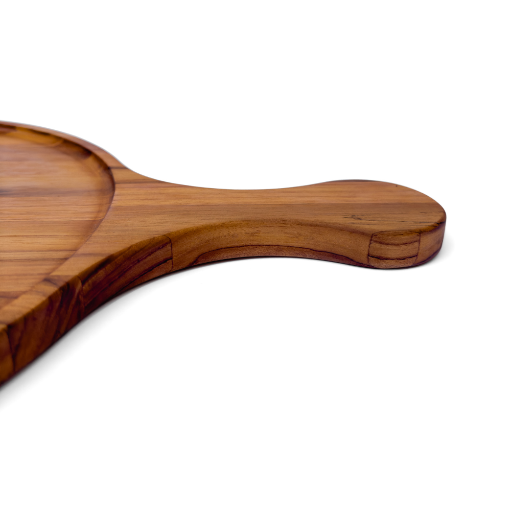Close-up of the ergonomic teakwood paddle handle on a round edge grain serving board.
