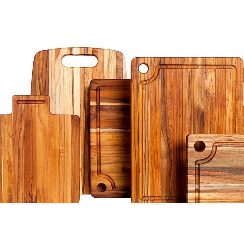 Various edge grain teak cutting and serving boards featuring different hole handle styles.